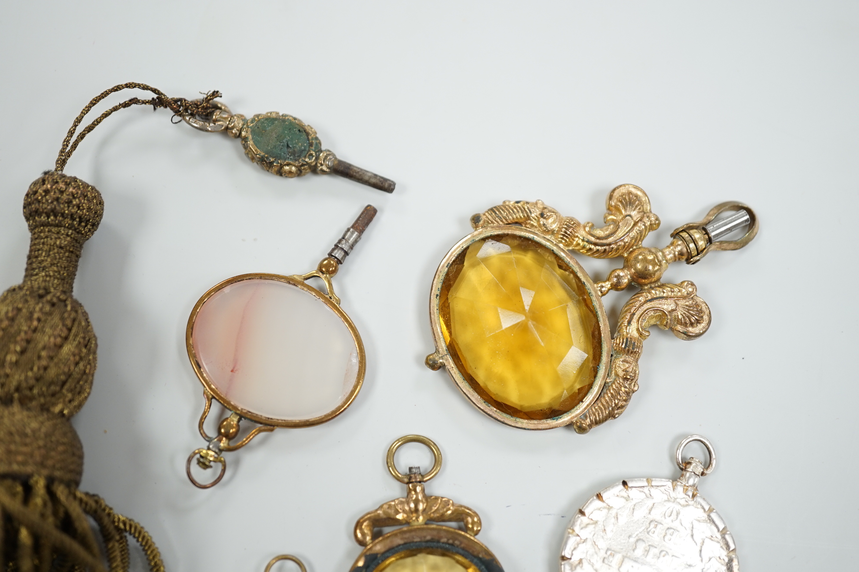 Ten assorted mainly 19th century base or yellow metal oval and gem set large watch keys, including agate and citrine paste and one set with French medallion, largest 69mm.
